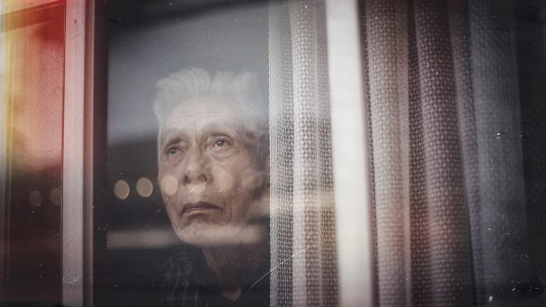 An elderly man stares out the window of his home near Tokyo, Japan.