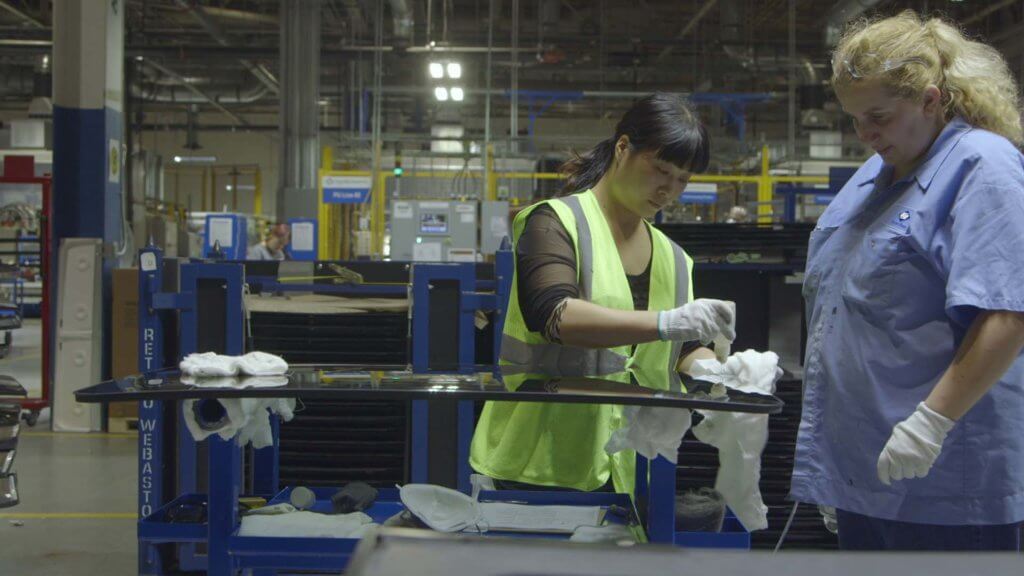 Yuzhu Yang (left) trains Lori Cochran at the Fuyao Glass America factory in Dayton, Ohio, in the documentary AMERICAN FACTORY