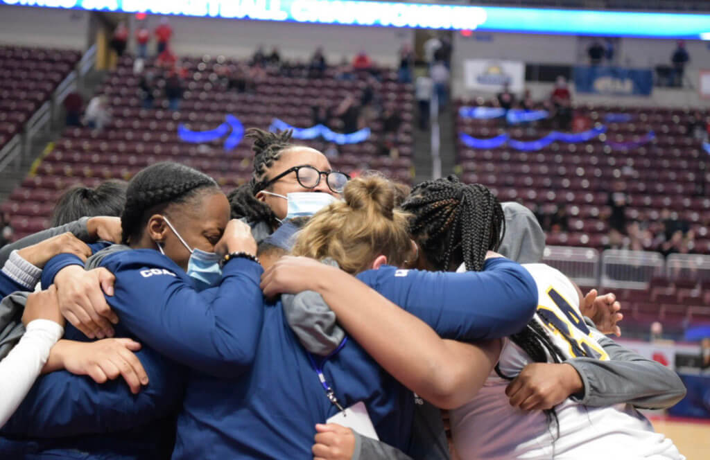 Team embracing on the court moments after winning state championship
